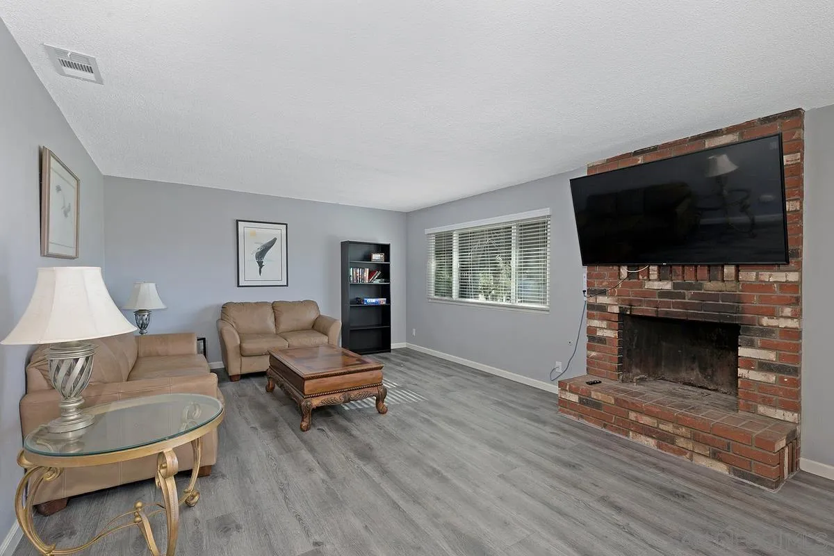 24567 Adams Avenue Murrieta, CA 92562 - Photo 6 of 42 a living room with furniture a flat screen tv and a fireplace