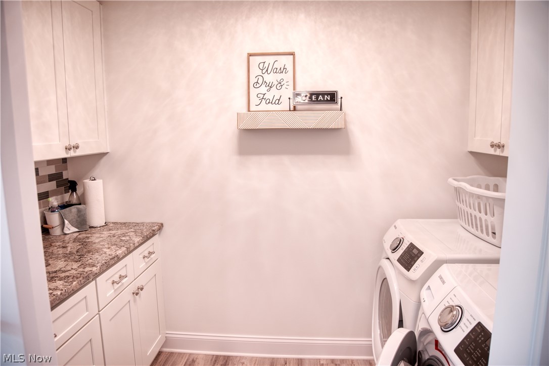 4553 Sharon Copley Road Medina, OH 44256 - Photo 18 of 32 Dedicated utility room featuring wood-finish flooring, white cabinetry, a speckled countertop, and a tiled backsplash