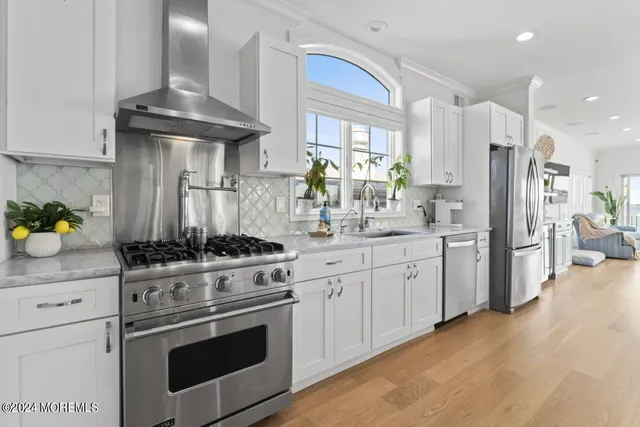 a kitchen with stainless steel appliances kitchen island granite countertop a stove a sink and a refrigerator
