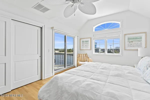 a bedroom with a bed mirror and a large window