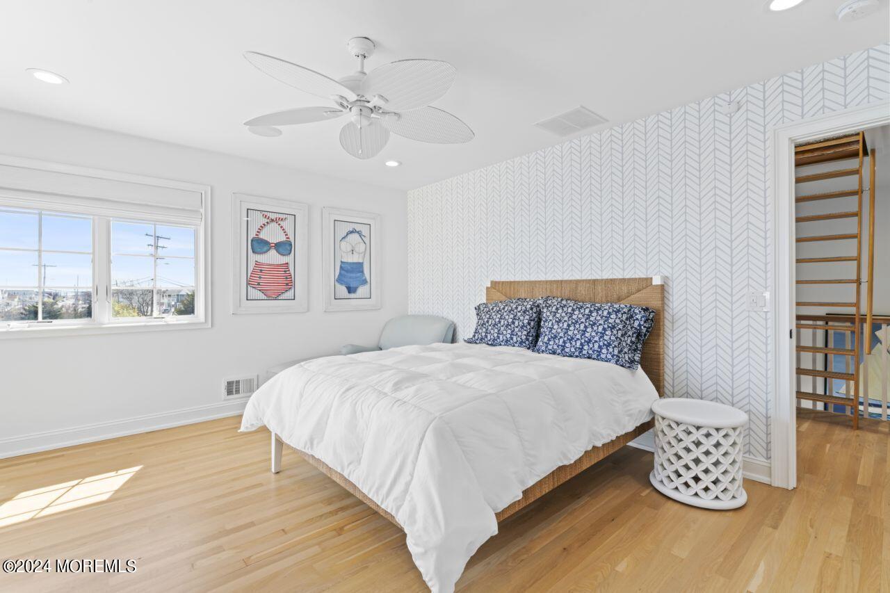1 Pershing Boulevard Lavallette, NJ 08735 - Photo 30 of 61 a large bed sitting in a bedroom next to a window with a bookshelf