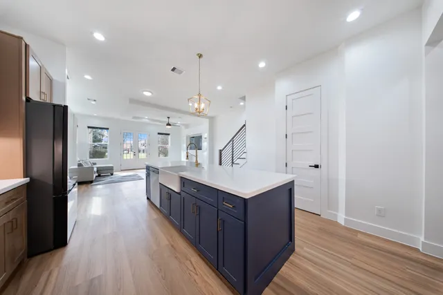 a kitchen with stainless steel appliances a sink a counter top space cabinets and wooden floor