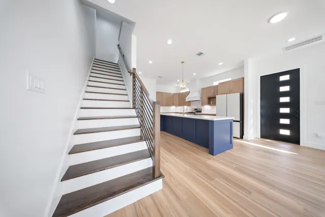 a kitchen with kitchen island white cabinets and refrigerator