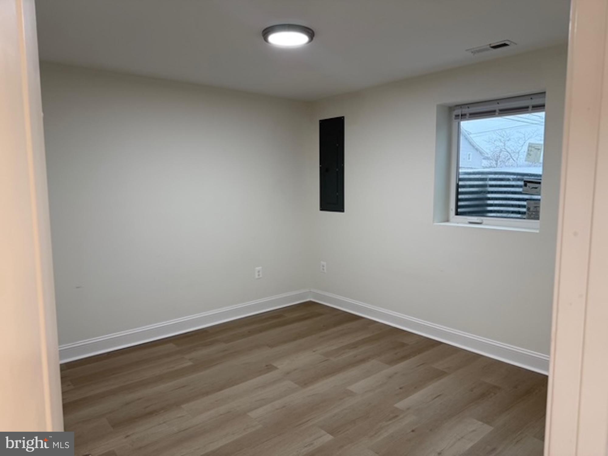 6409 63rd Place Riverdale, MD 20737 - Photo 22 of 30 an empty room with wooden floor and windows