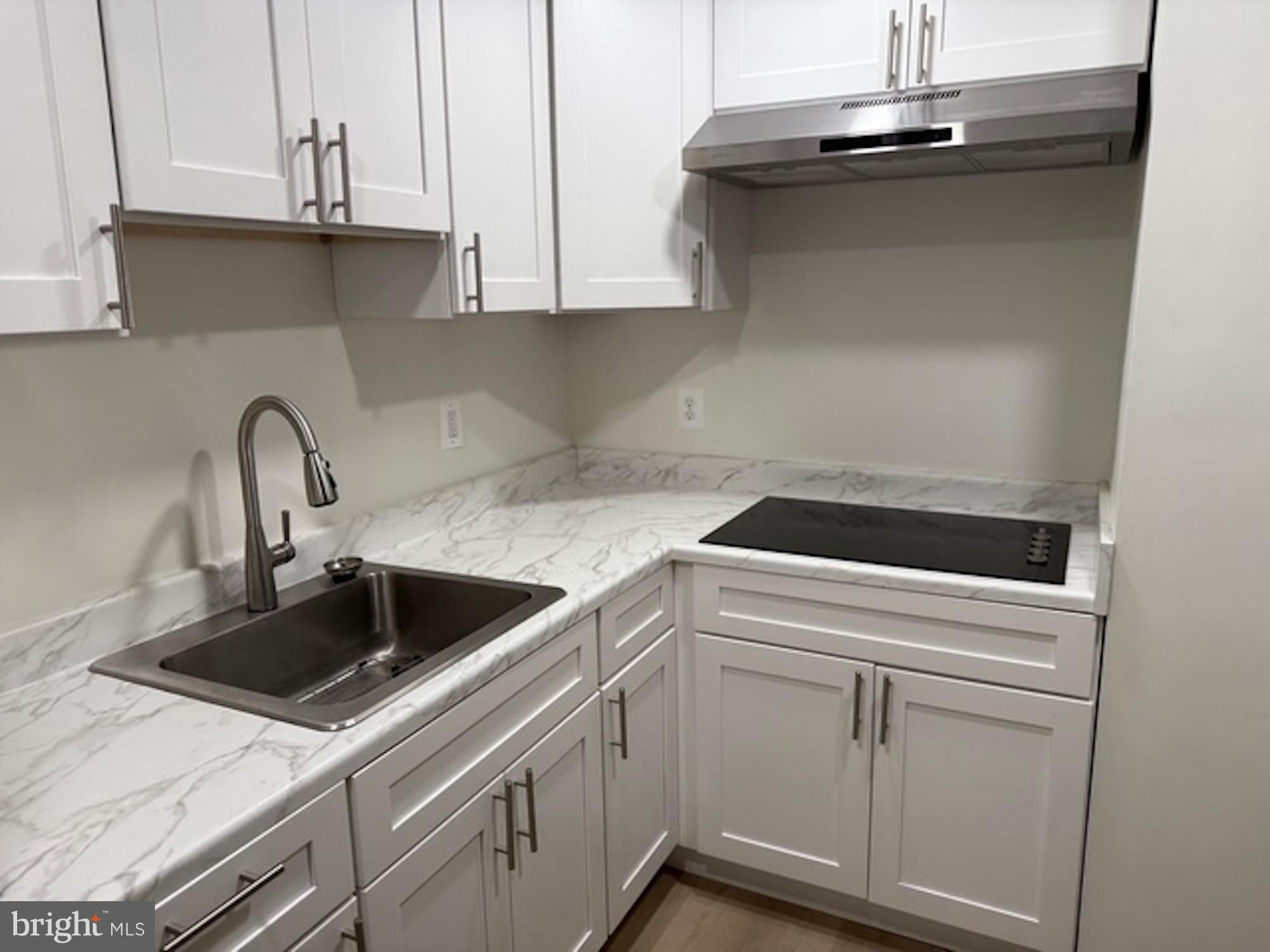 6409 63rd Place Riverdale, MD 20737 - Photo 28 of 30 a kitchen with white cabinets and white appliances