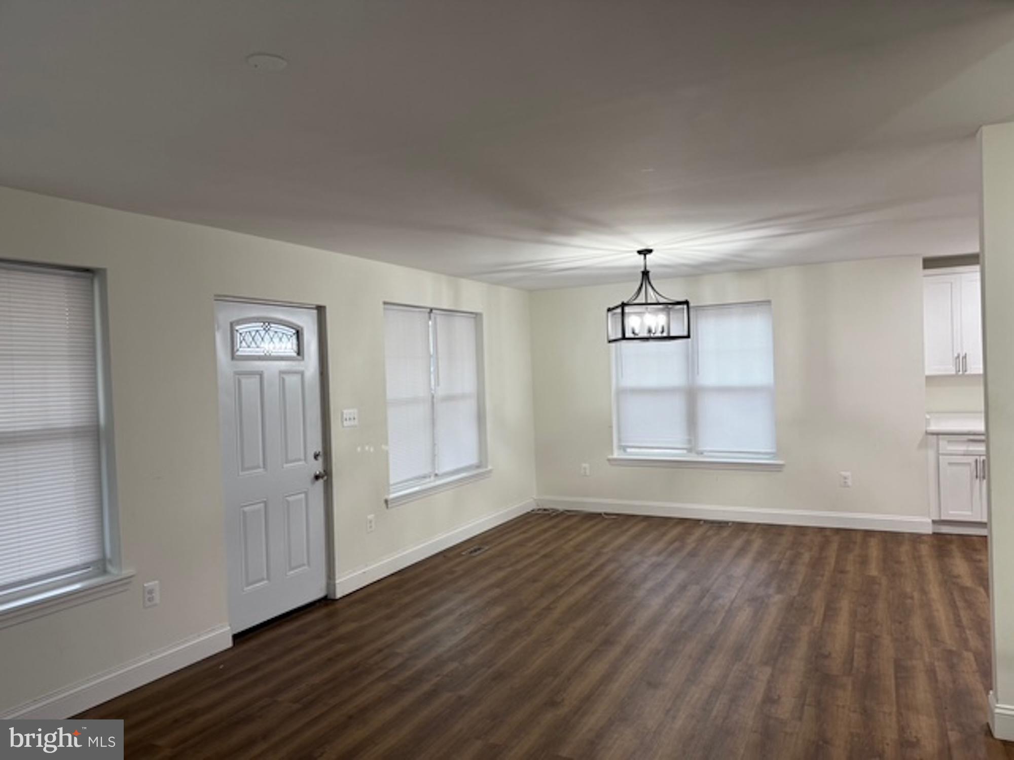 6409 63rd Place Riverdale, MD 20737 - Photo 4 of 30 an empty room with wooden floor cabinet and windows