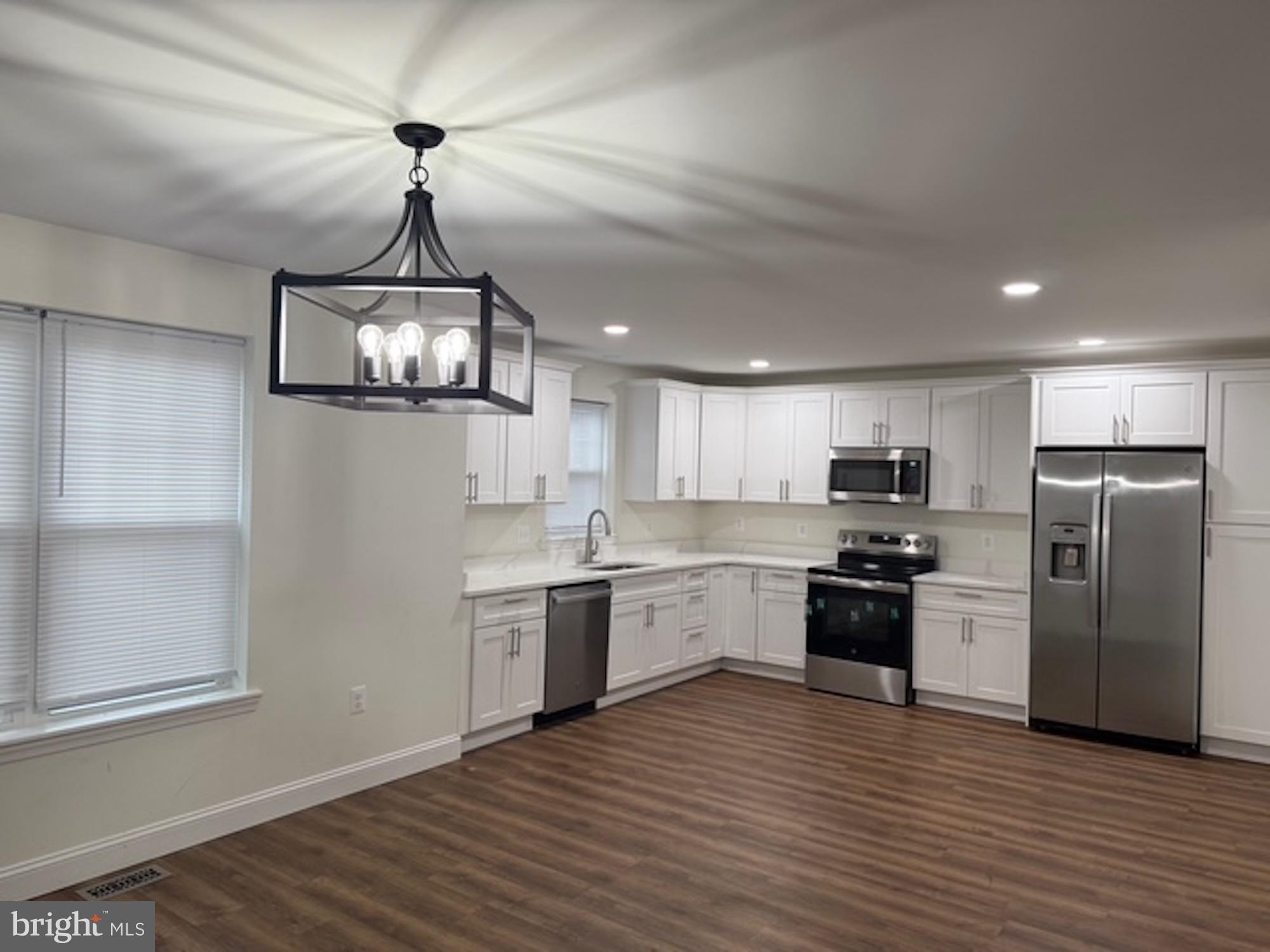 6409 63rd Place Riverdale, MD 20737 - Photo 5 of 30 a kitchen with stainless steel appliances granite countertop a sink a stove a refrigerator cabinets and wooden floor