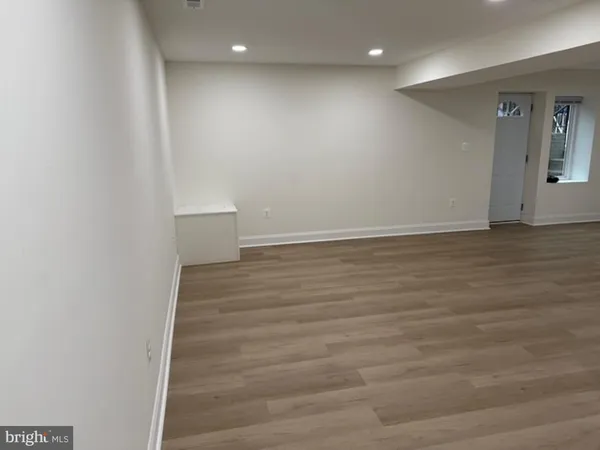 a view of an empty room with wooden floor