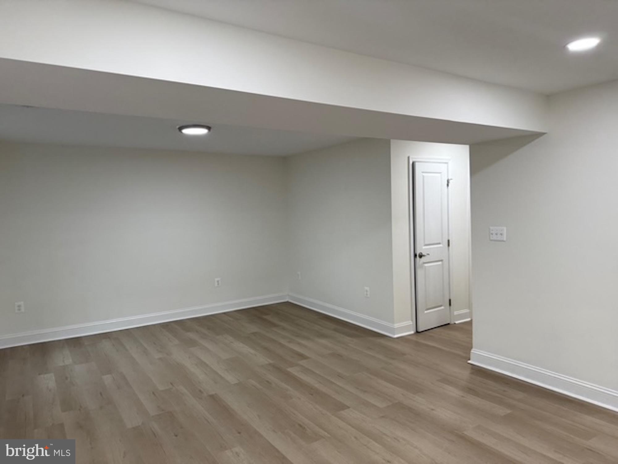 6409 63rd Place Riverdale, MD 20737 - Photo 9 of 22 an empty room with wooden floor and windows