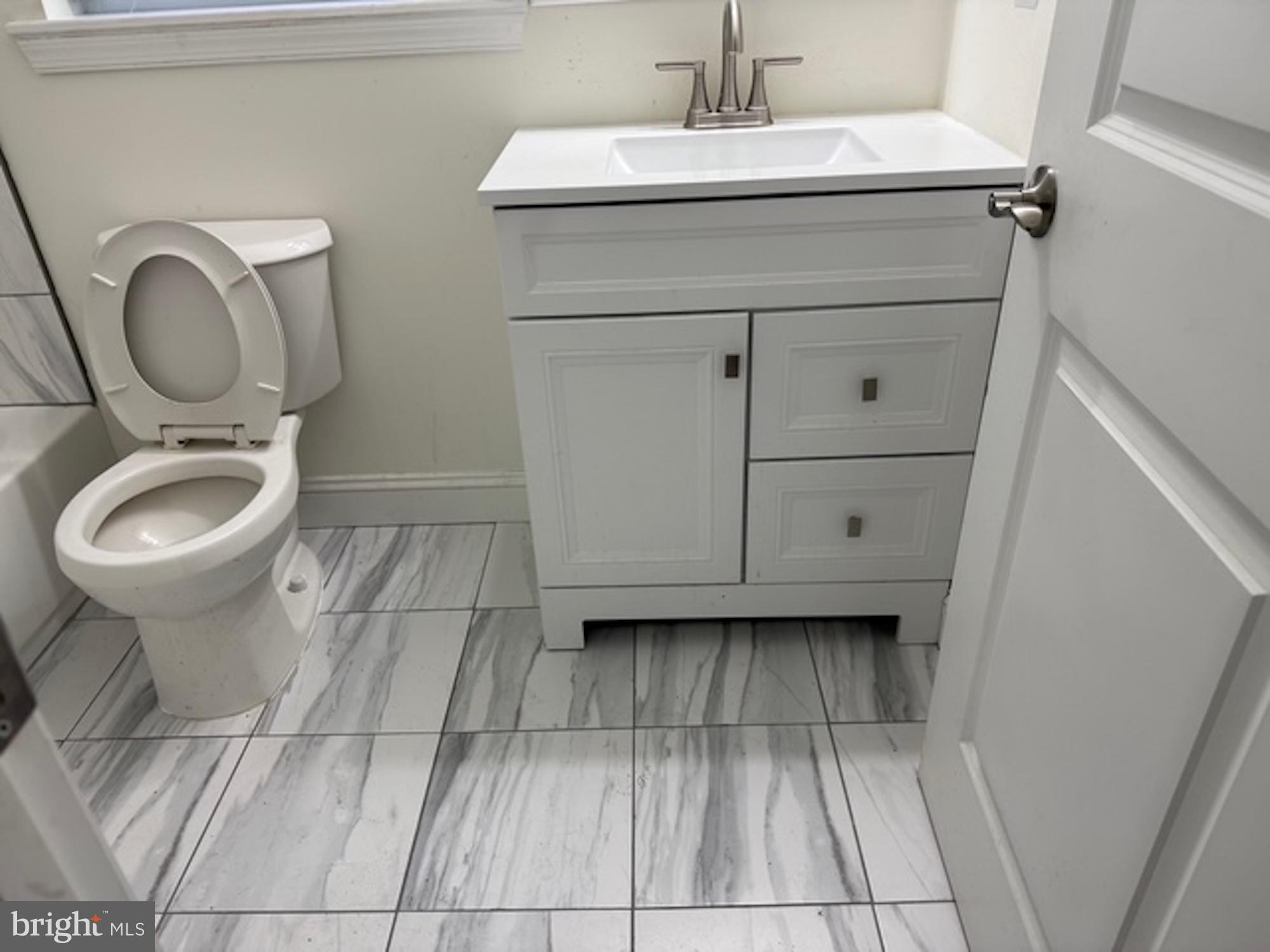 6409 63rd Place Riverdale, MD 20737 - Photo 10 of 30 a bathroom with a sink toilet and a mirror