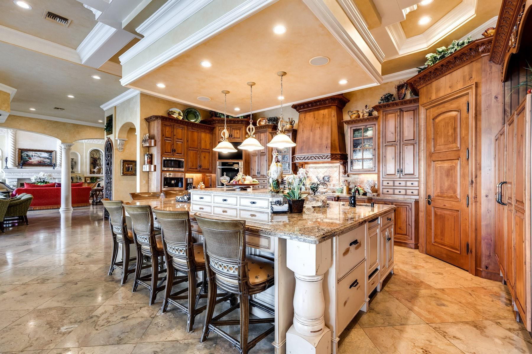 4089 Southeast Old St Lucie Boulevard Stuart, FL 34996 - Photo 24 of 99 a kitchen with stainless steel appliances kitchen island granite countertop a table chairs and a refrigerator