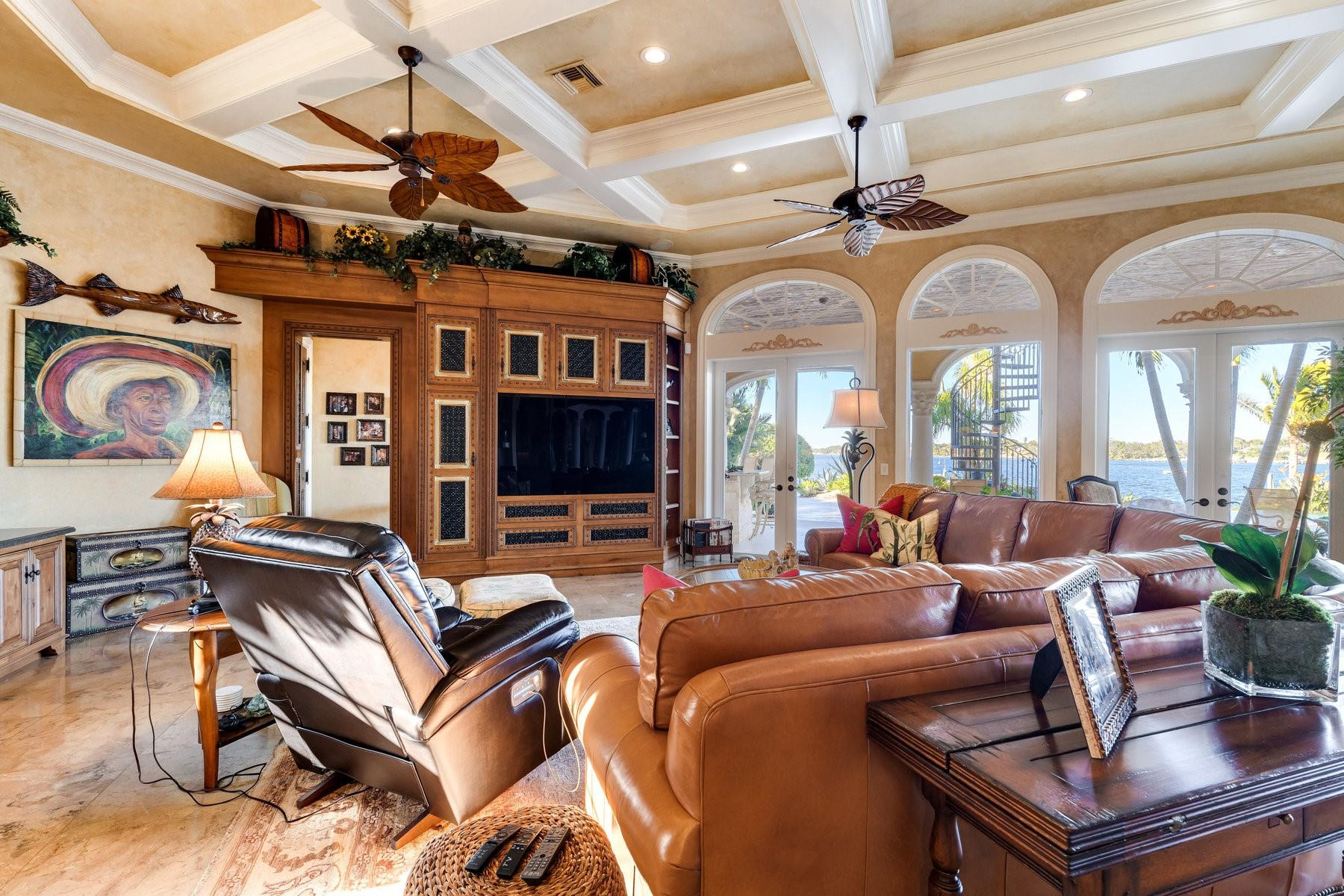 4089 Southeast Old St Lucie Boulevard Stuart, FL 34996 - Photo 26 of 99 a living room with furniture a fireplace and a chandelier