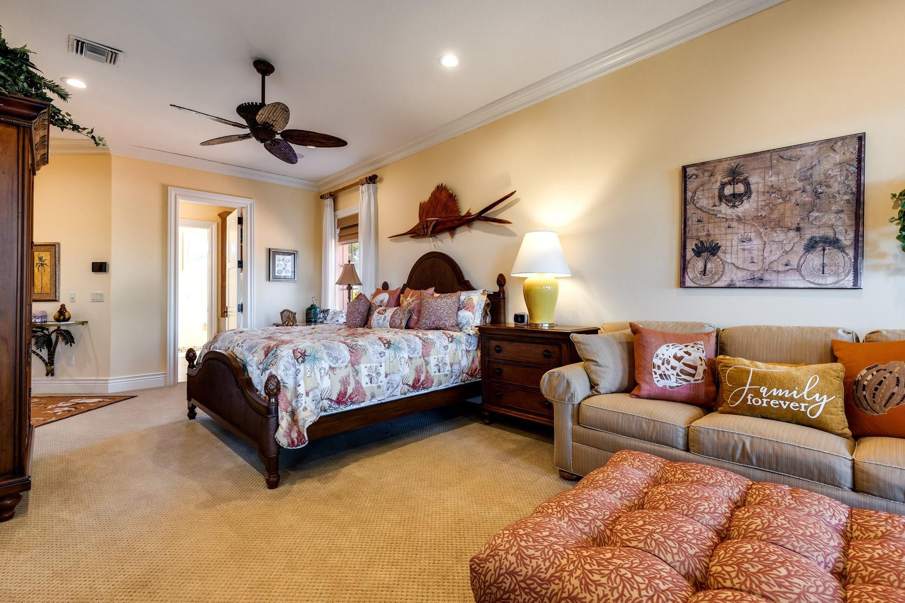 4089 Southeast Old St Lucie Boulevard Stuart, FL 34996 - Photo 64 of 99 a bedroom with a bed couches and chandelier