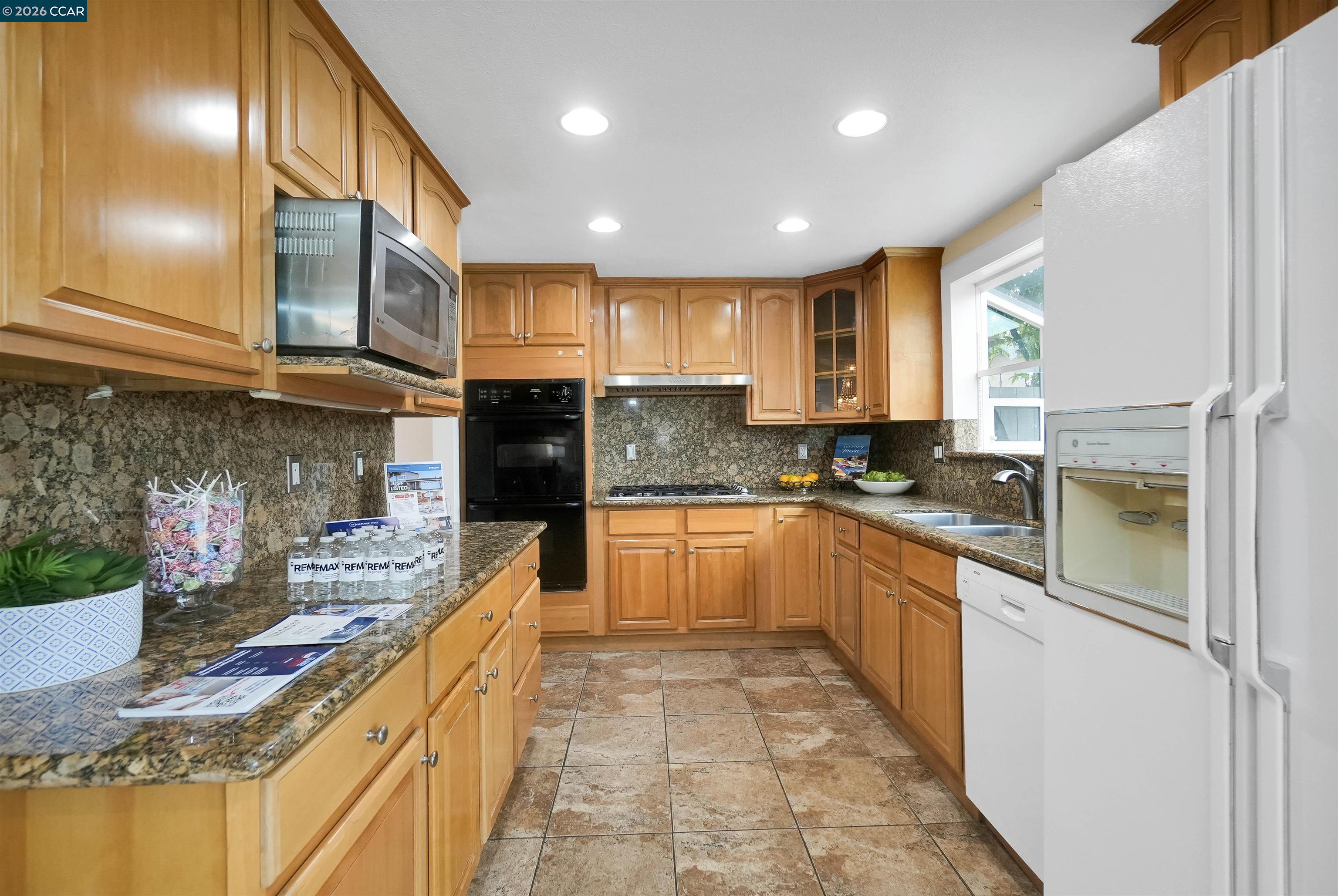 922 Coral Drive Rodeo, CA 94572 - Photo 23 of 59 a large kitchen with stainless steel appliances granite countertop a refrigerator a sink dishwasher a stove and white cabinets with wooden floor