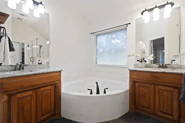 a spacious bathroom with a granite countertop sink mirror and bathtub