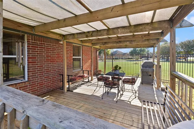 a view of a patio with a dining table and chairs with wooden floor