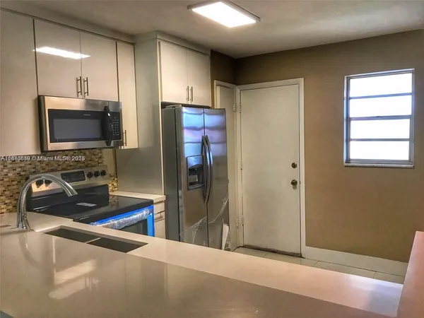 a kitchen with stainless steel appliances granite countertop a refrigerator and a sink