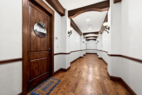 a view of a hallway with wooden floor and staircase
