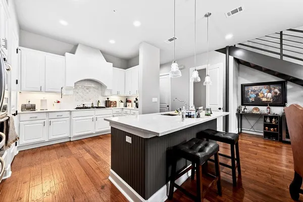 a kitchen with a sink cabinets and wooden floor