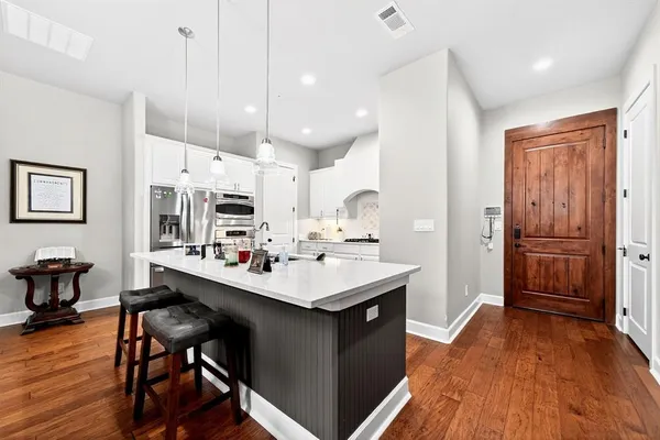 a kitchen with a sink appliances and wooden floor