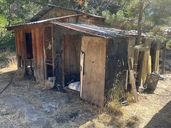a backyard of a house with barbeque oven and yard