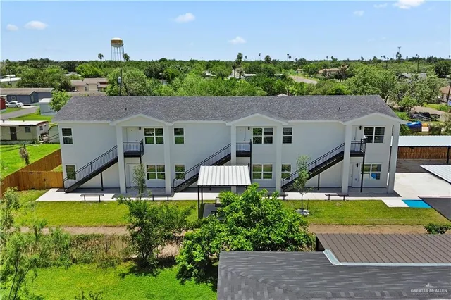 a aerial view of a house with table and chairs under an umbrella