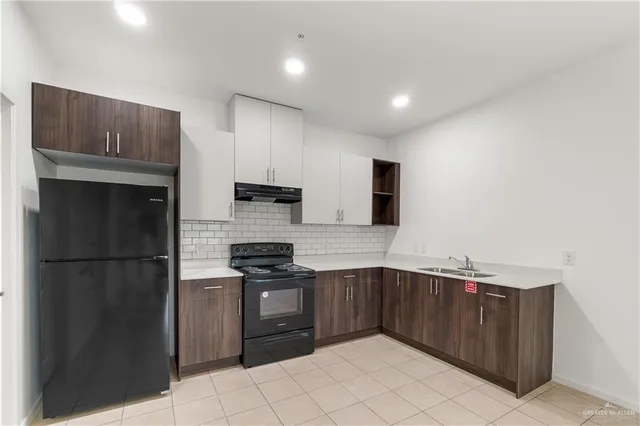 a kitchen with stainless steel appliances granite countertop a refrigerator and a sink