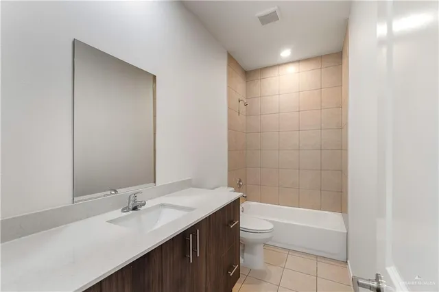a bathroom with a granite countertop sink a toilet and shower