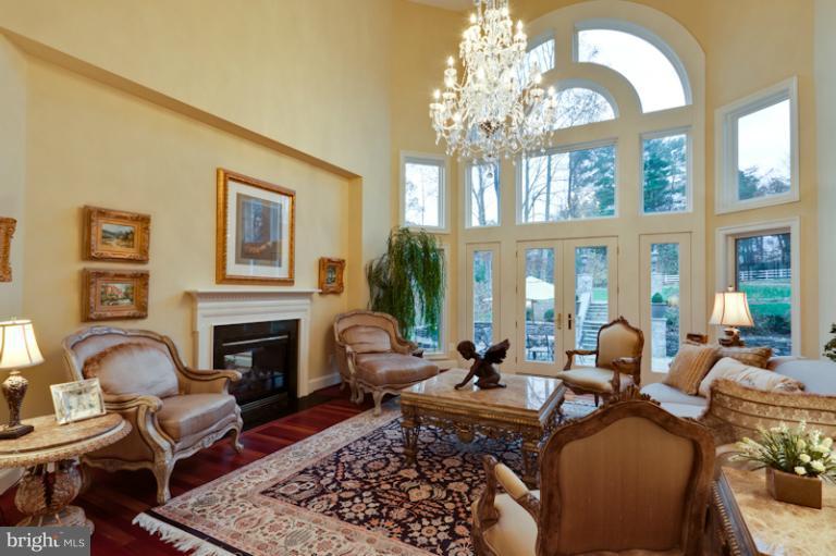903 Georgetown Ridge Court McLean, VA 22102 - Photo 16 of 27 a living room with furniture a chandelier and a fireplace