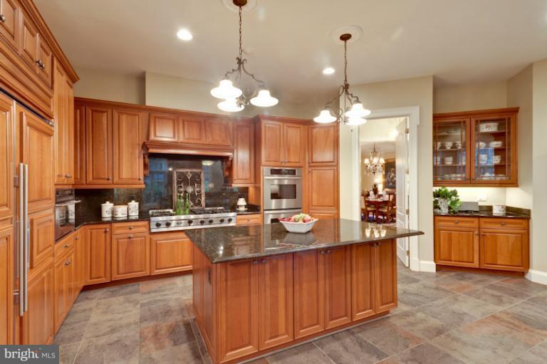 903 Georgetown Ridge Court McLean, VA 22102 - Photo 10 of 27 a kitchen with stainless steel appliances granite countertop wooden cabinets a stove top oven a sink and dishwasher