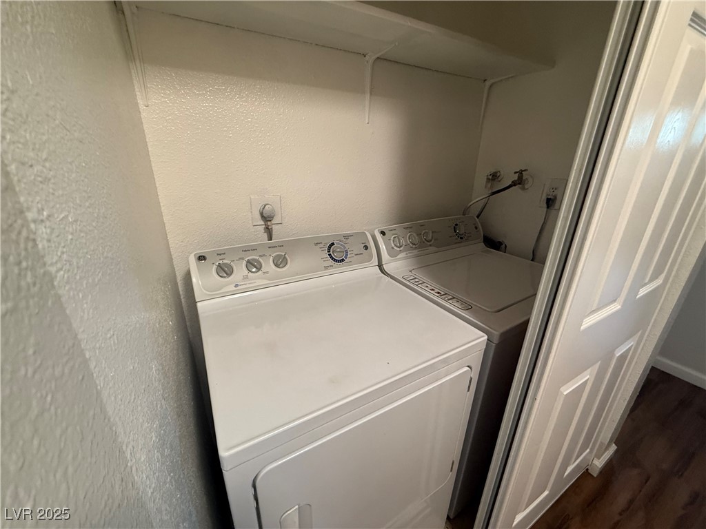 2853 Wheelwright Drive, Unit A Las Vegas, NV 89121 - Photo 11 of 12 Laundry room featuring dark wood-style flooring, washing machine and clothes dryer, and a textured wall