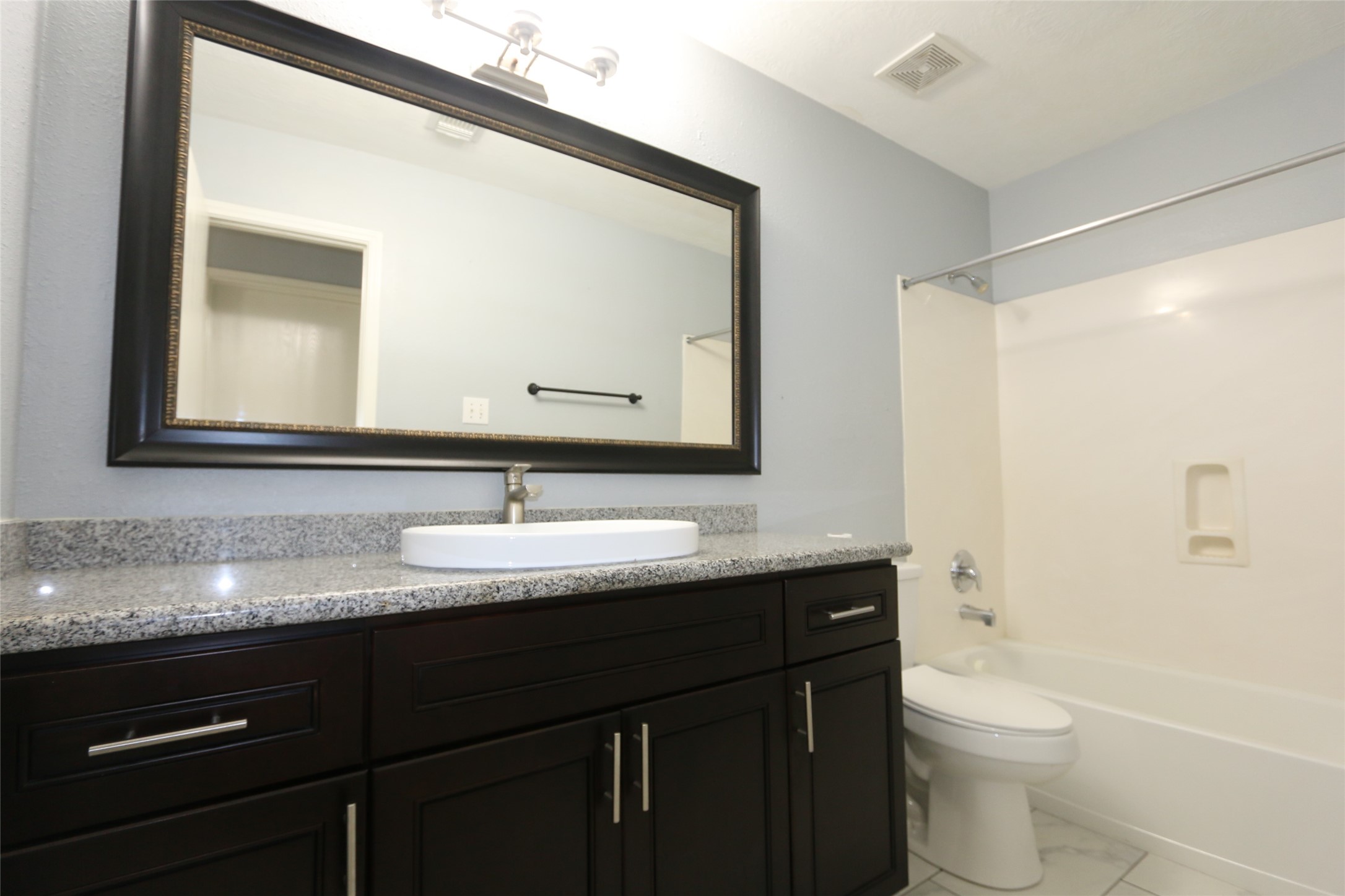 5914 Ridgebriar Lane Houston, TX 77085 - Photo 6 of 8 a bathroom with a granite countertop sink toilet a large mirror and shower