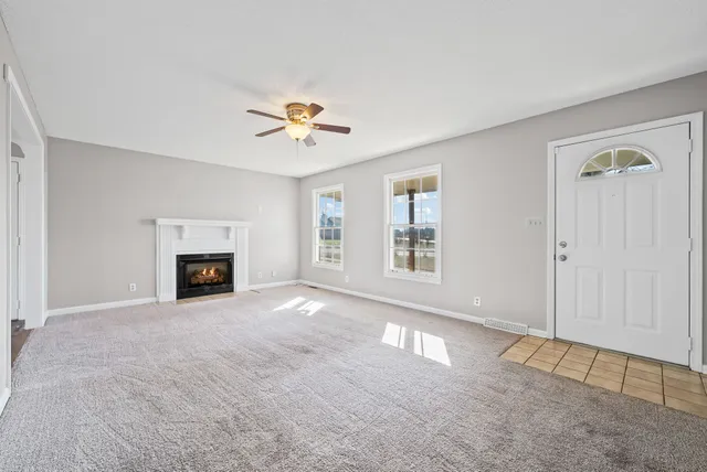 an empty room with windows and fireplace