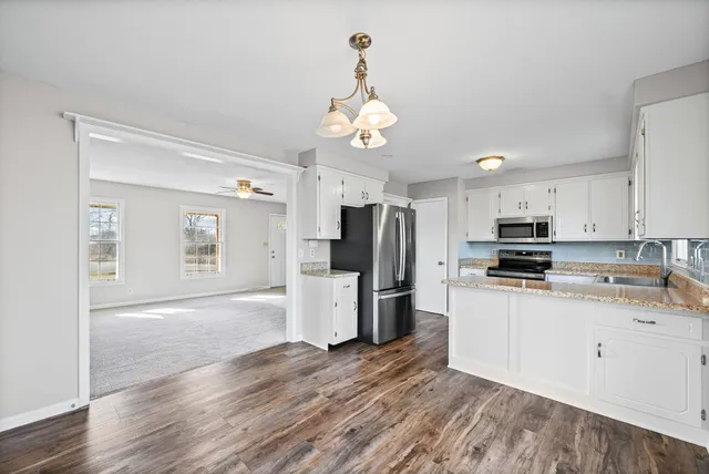 a kitchen with refrigerator cabinets and wooden floor