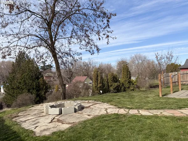 a backyard of a house with table and chairs