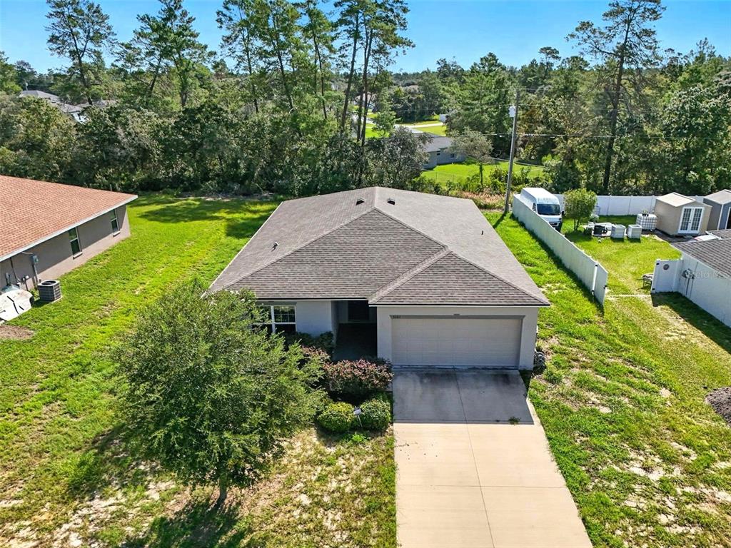 a aerial view of a house with swimming pool next to a yard