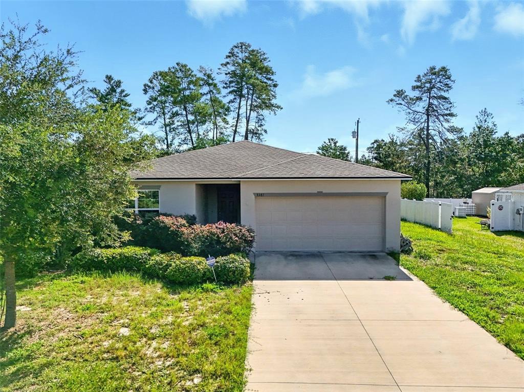 3381 Southwest 129th Loop Ocala, FL 34473 - Photo 2 of 35 a front view of a house with a yard and potted plants