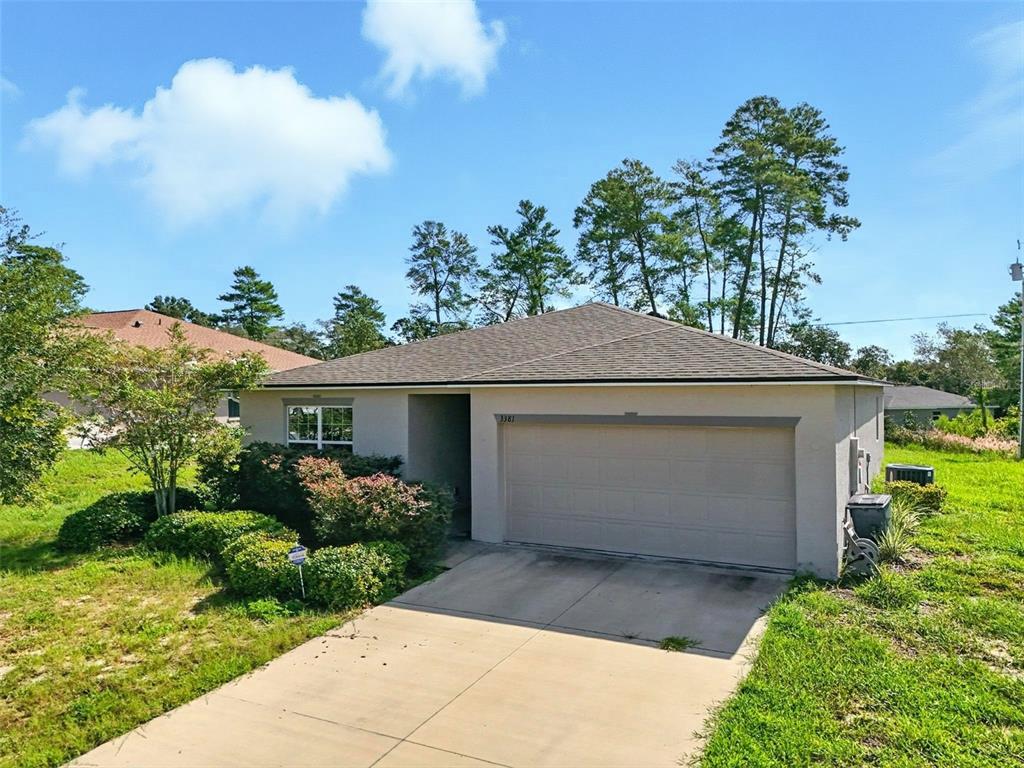 3381 Southwest 129th Loop Ocala, FL 34473 - Photo 5 of 35 a front view of house with yard and trees in the background