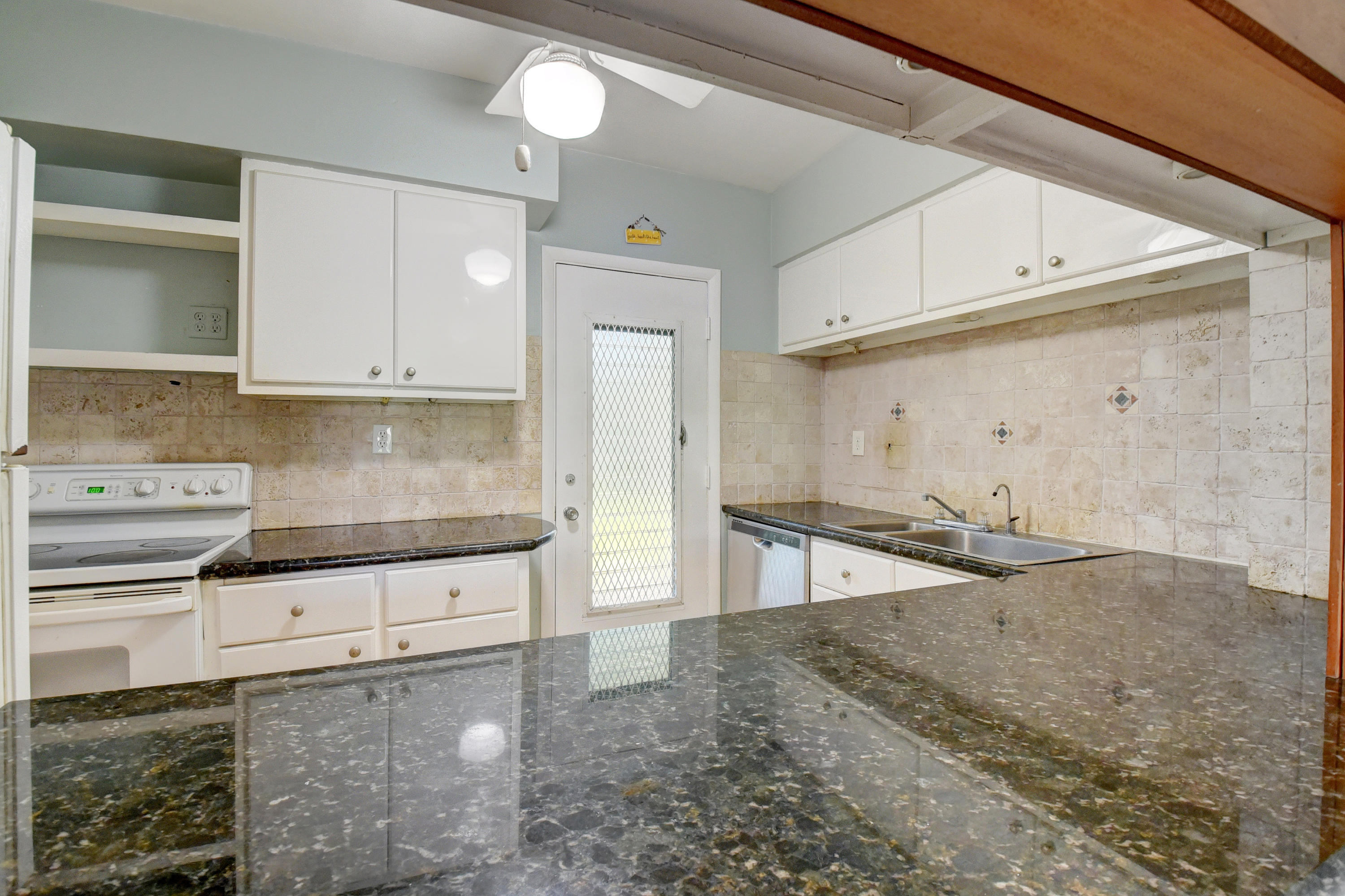 2700 Banyan Road, Unit 2C Boca Raton, FL 33432 - Photo 18 of 33 a kitchen with granite countertop a sink and a stove