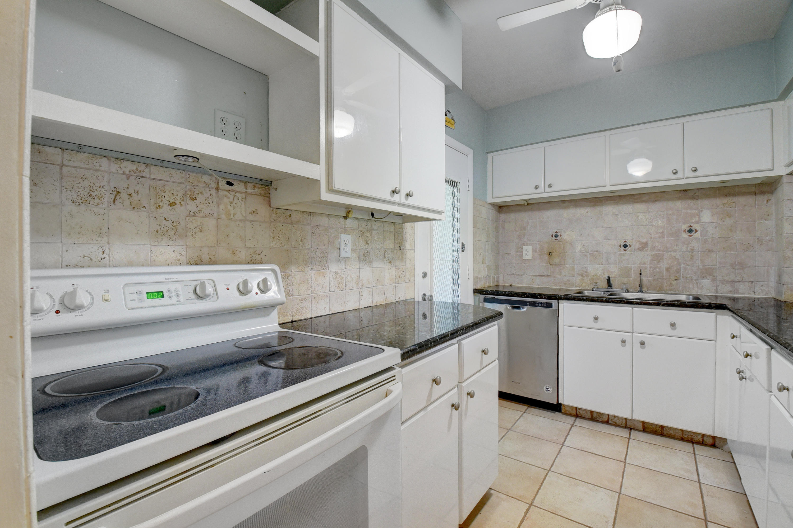2700 Banyan Road, Unit 2C Boca Raton, FL 33432 - Photo 20 of 33 a kitchen with granite countertop a sink and a stove