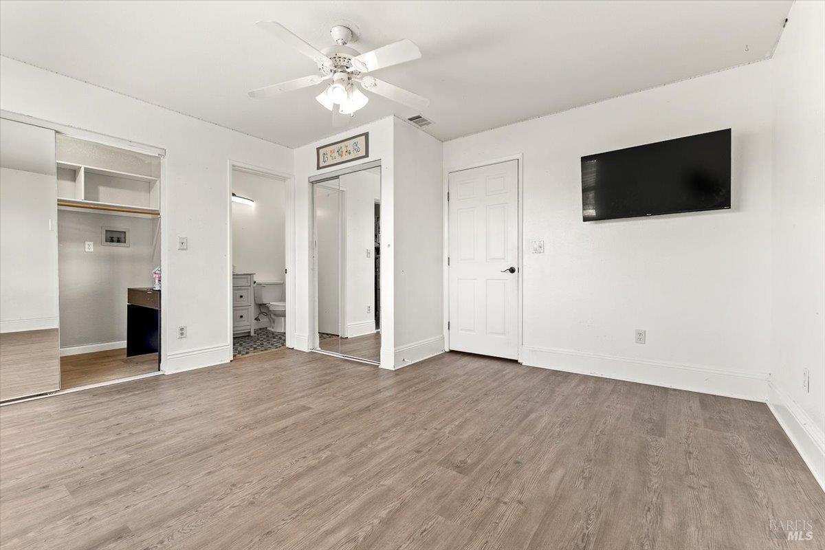 4457 Graywhaler Lane Rohnert Park, CA 94928 - Photo 24 of 51 a view of an empty room with wooden floor and a kitchen