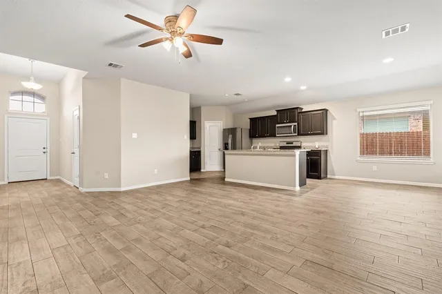 a view of kitchen with microwave stove top oven and refrigerator