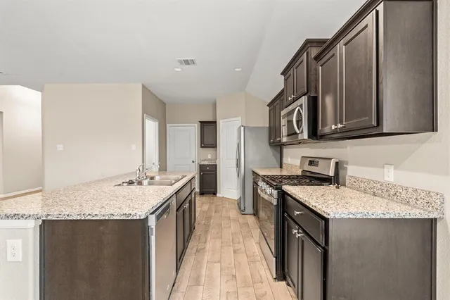 a kitchen with a sink stove and cabinets