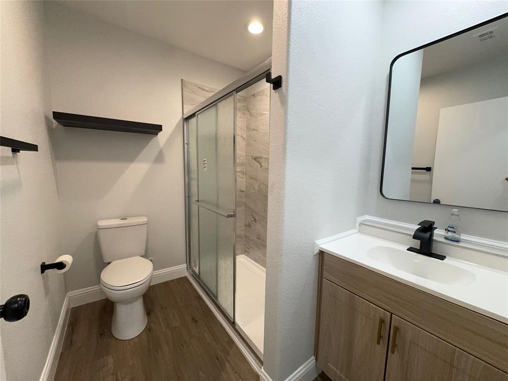 2909 Alexander Avenue Waco, TX 76708 - Photo 11 of 27 Bathroom with a shower stall, vanity, and dark wood-type flooring