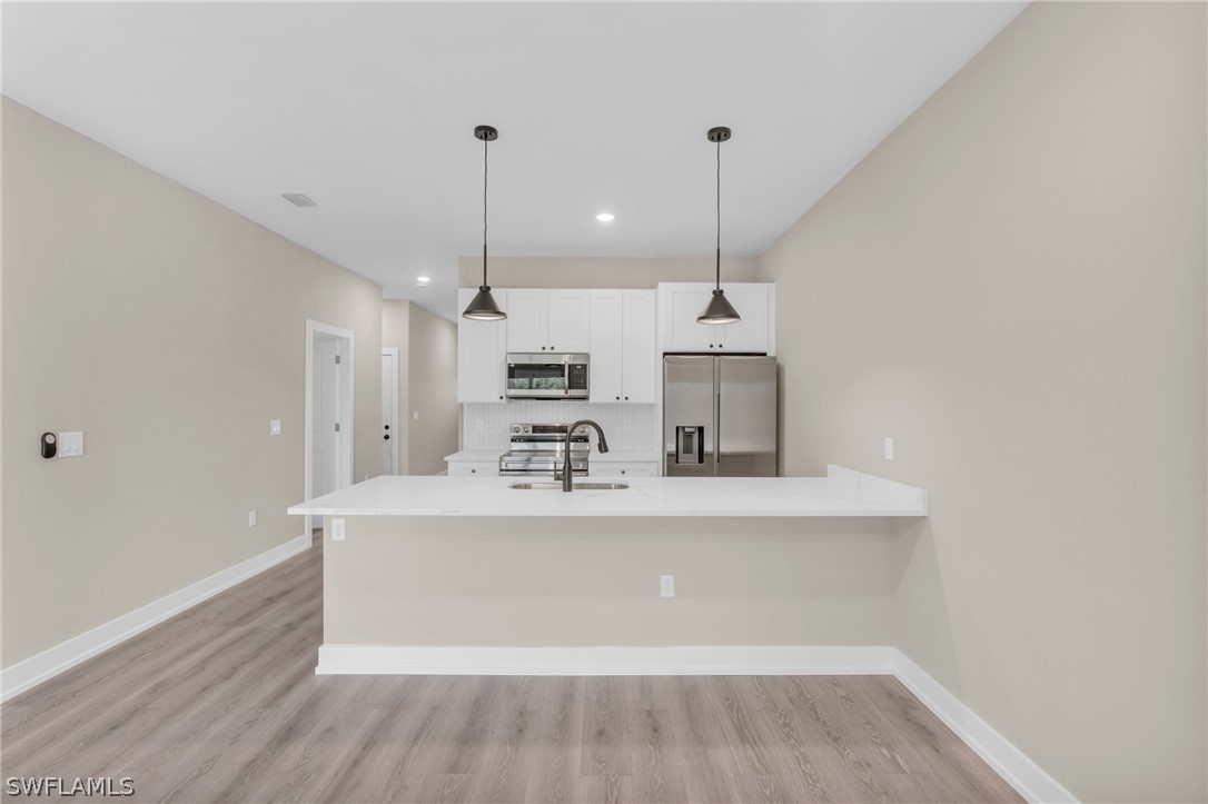 12208 Tetzel Avenue Port Charlotte, FL 33981 - Photo 11 of 45 a view of a kitchen with kitchen island a sink stainless steel appliances and cabinets
