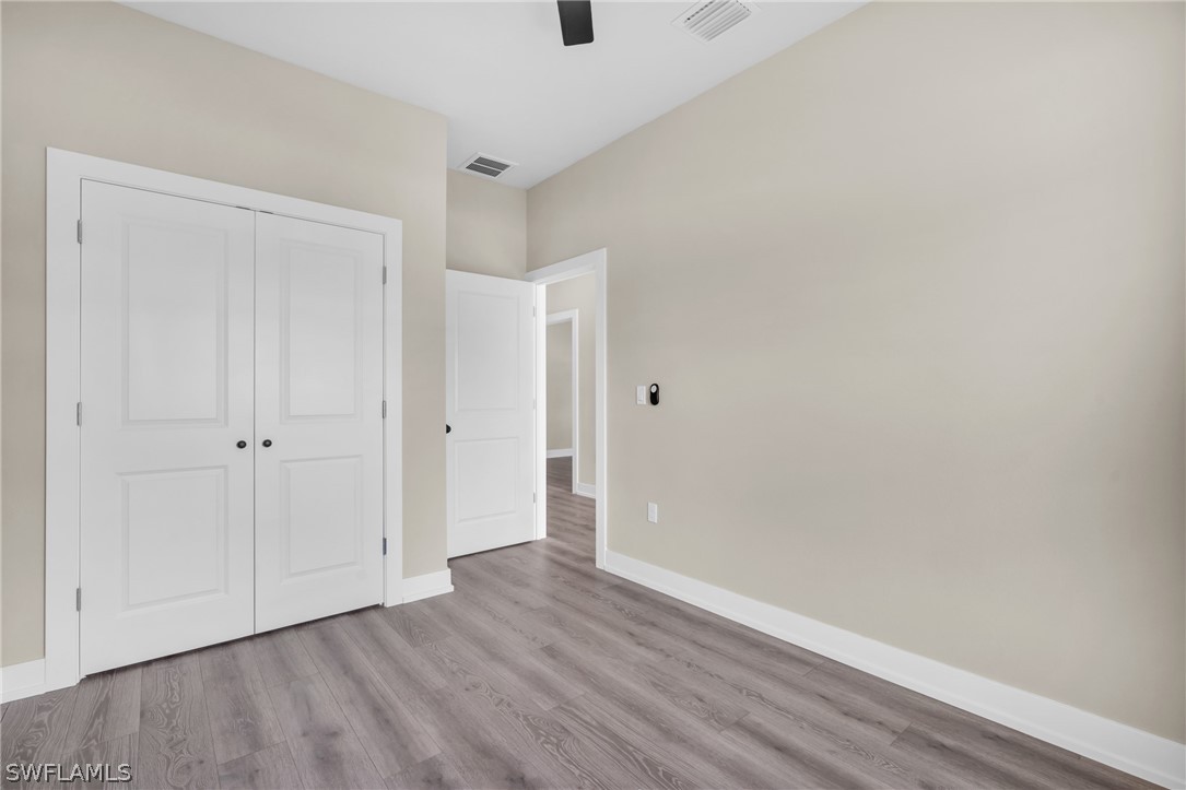 12208 Tetzel Avenue Port Charlotte, FL 33981 - Photo 13 of 45 a view of an empty room with wooden floor