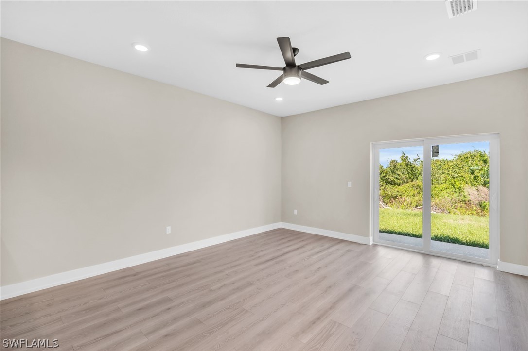 12208 Tetzel Avenue Port Charlotte, FL 33981 - Photo 15 of 45 an empty room with wooden floor fan and windows