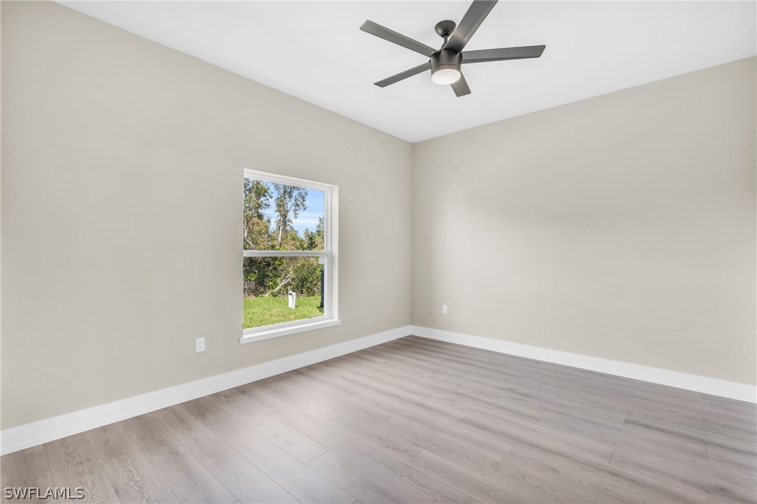 12208 Tetzel Avenue Port Charlotte, FL 33981 - Photo 17 of 45 wooden floor in an empty room with a window