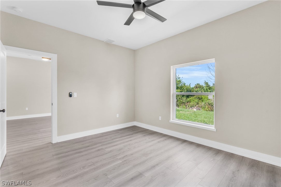12208 Tetzel Avenue Port Charlotte, FL 33981 - Photo 18 of 45 wooden floor in an empty room with a window