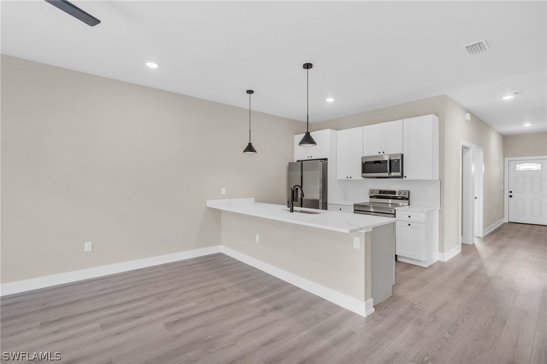 12208 Tetzel Avenue Port Charlotte, FL 33981 - Photo 21 of 45 a view of kitchen with stainless steel appliances refrigerator stove microwave and cabinets
